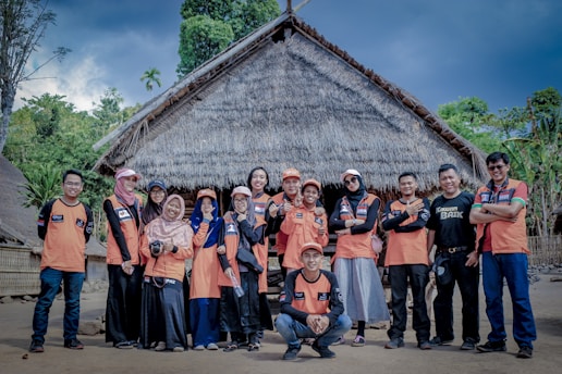 group of people standing near brown wooden house