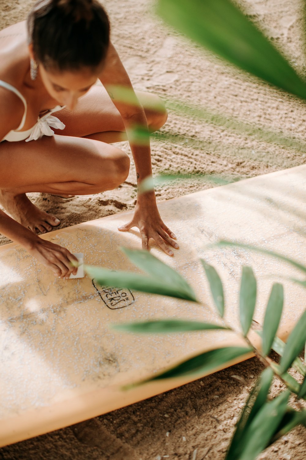 woman in white bikini lying on white sand during daytime