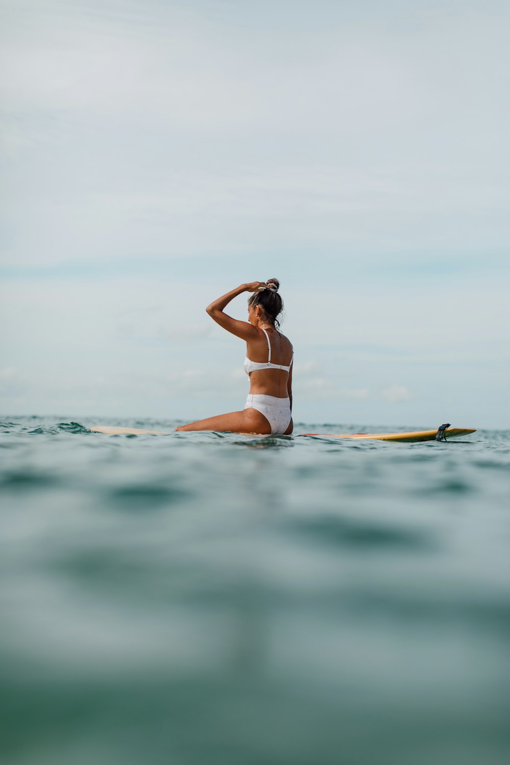 woman in white bikini on body of water during daytime