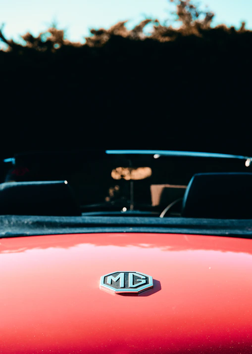 man in black jacket driving red car