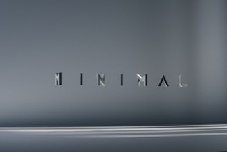 The image consists of the word 'MINIMAL' in a modern, sleek font. The background is a smooth gradient of gray shades, which emphasizes the simplicity and elegance of the design.