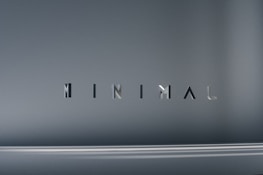 The image consists of the word 'MINIMAL' in a modern, sleek font. The background is a smooth gradient of gray shades, which emphasizes the simplicity and elegance of the design.