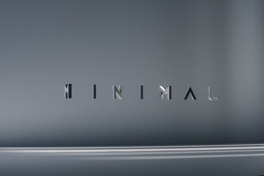 The image consists of the word 'MINIMAL' in a modern, sleek font. The background is a smooth gradient of gray shades, which emphasizes the simplicity and elegance of the design.