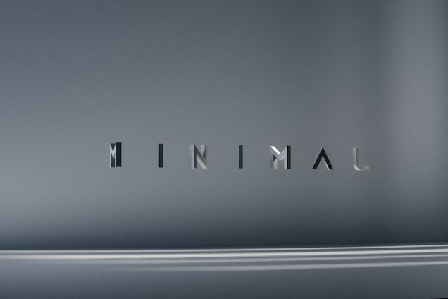 The image consists of the word 'MINIMAL' in a modern, sleek font. The background is a smooth gradient of gray shades, which emphasizes the simplicity and elegance of the design.