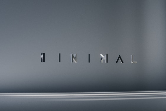 The image consists of the word 'MINIMAL' in a modern, sleek font. The background is a smooth gradient of gray shades, which emphasizes the simplicity and elegance of the design.