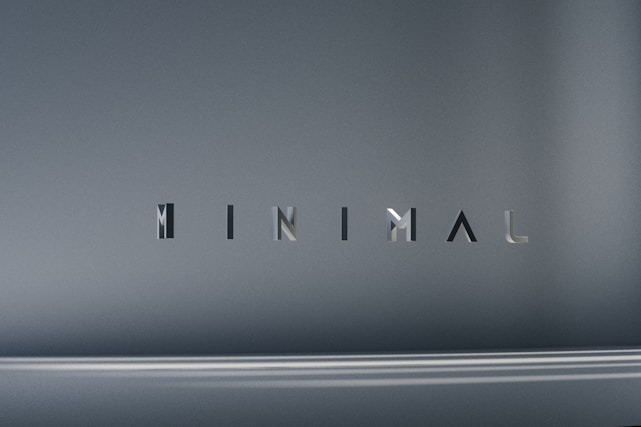 The image consists of the word 'MINIMAL' in a modern, sleek font. The background is a smooth gradient of gray shades, which emphasizes the simplicity and elegance of the design.