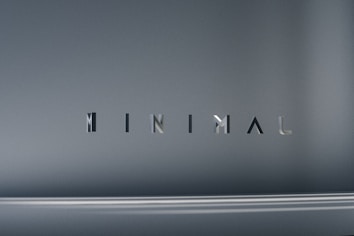 The image consists of the word 'MINIMAL' in a modern, sleek font. The background is a smooth gradient of gray shades, which emphasizes the simplicity and elegance of the design.