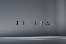 The image consists of the word 'MINIMAL' in a modern, sleek font. The background is a smooth gradient of gray shades, which emphasizes the simplicity and elegance of the design.