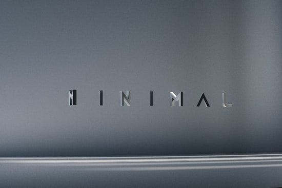 The image consists of the word 'MINIMAL' in a modern, sleek font. The background is a smooth gradient of gray shades, which emphasizes the simplicity and elegance of the design.