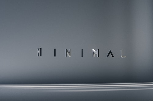 The image consists of the word 'MINIMAL' in a modern, sleek font. The background is a smooth gradient of gray shades, which emphasizes the simplicity and elegance of the design.