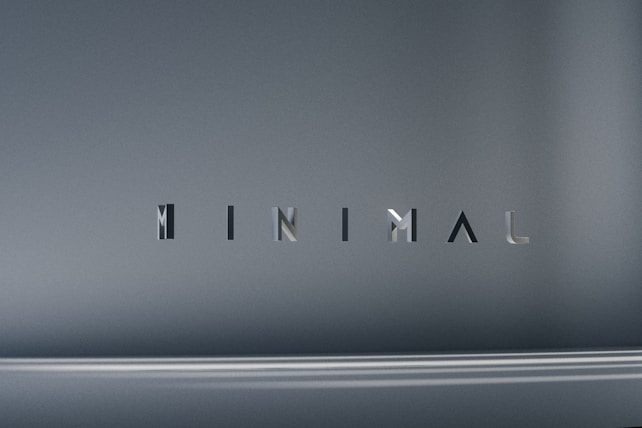 The image consists of the word 'MINIMAL' in a modern, sleek font. The background is a smooth gradient of gray shades, which emphasizes the simplicity and elegance of the design.