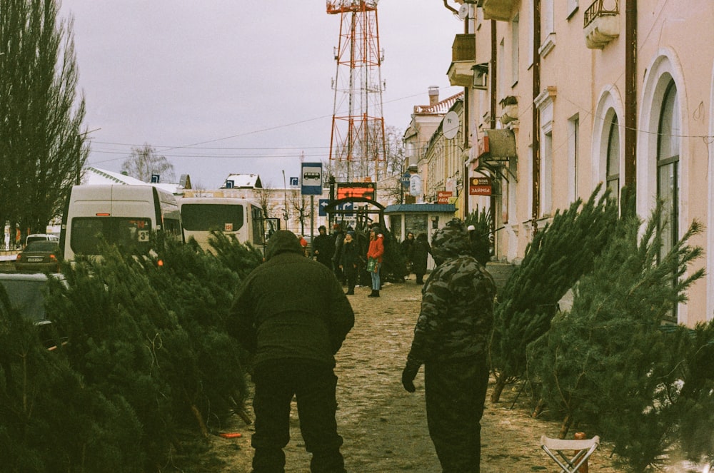 man in green jacket standing near white building during daytime