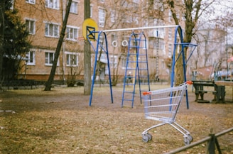 blue and yellow metal swing near brown concrete building during daytime