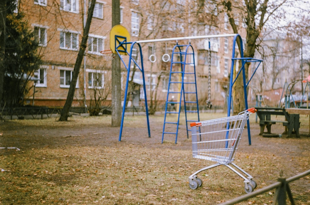 blue and yellow metal swing near brown concrete building during daytime