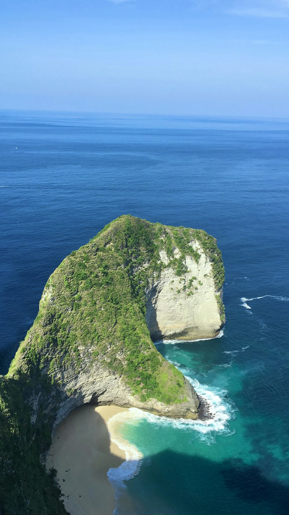 green and brown rock formation on blue sea during daytime