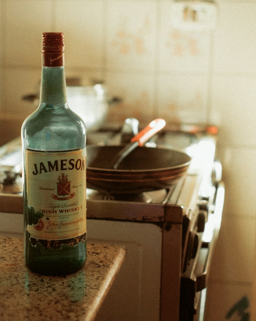 green glass bottle on brown wooden table