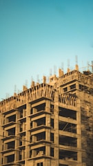 Modern concrete slab house under construction with clear blue sky.