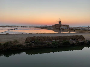 A vibrant sunset over the vast salt flats with travelers exploring the landscape.