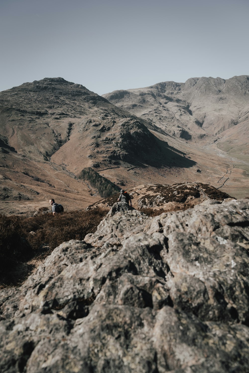 person in black jacket standing on rocky mountain during daytime