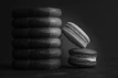 Black and white artistic shot of stacked rings on a textured surface, emphasizing refined streetwear details.