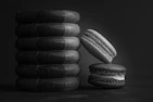 Black and white artistic shot of stacked rings on a textured surface, emphasizing refined streetwear details.