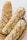 Three rustic loaves of bread with a golden, crusty exterior rest in a woven basket. The bread surface is uneven with a textured crust, suggesting a hearty, artisanal quality.