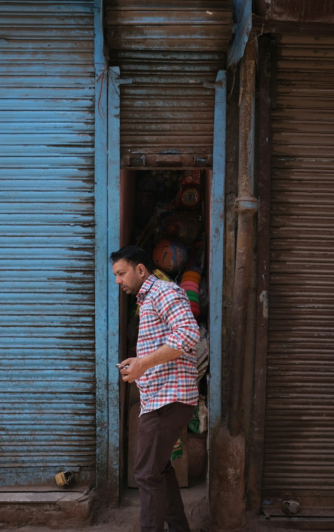 woman in blue and white plaid shirt standing beside brown wooden door