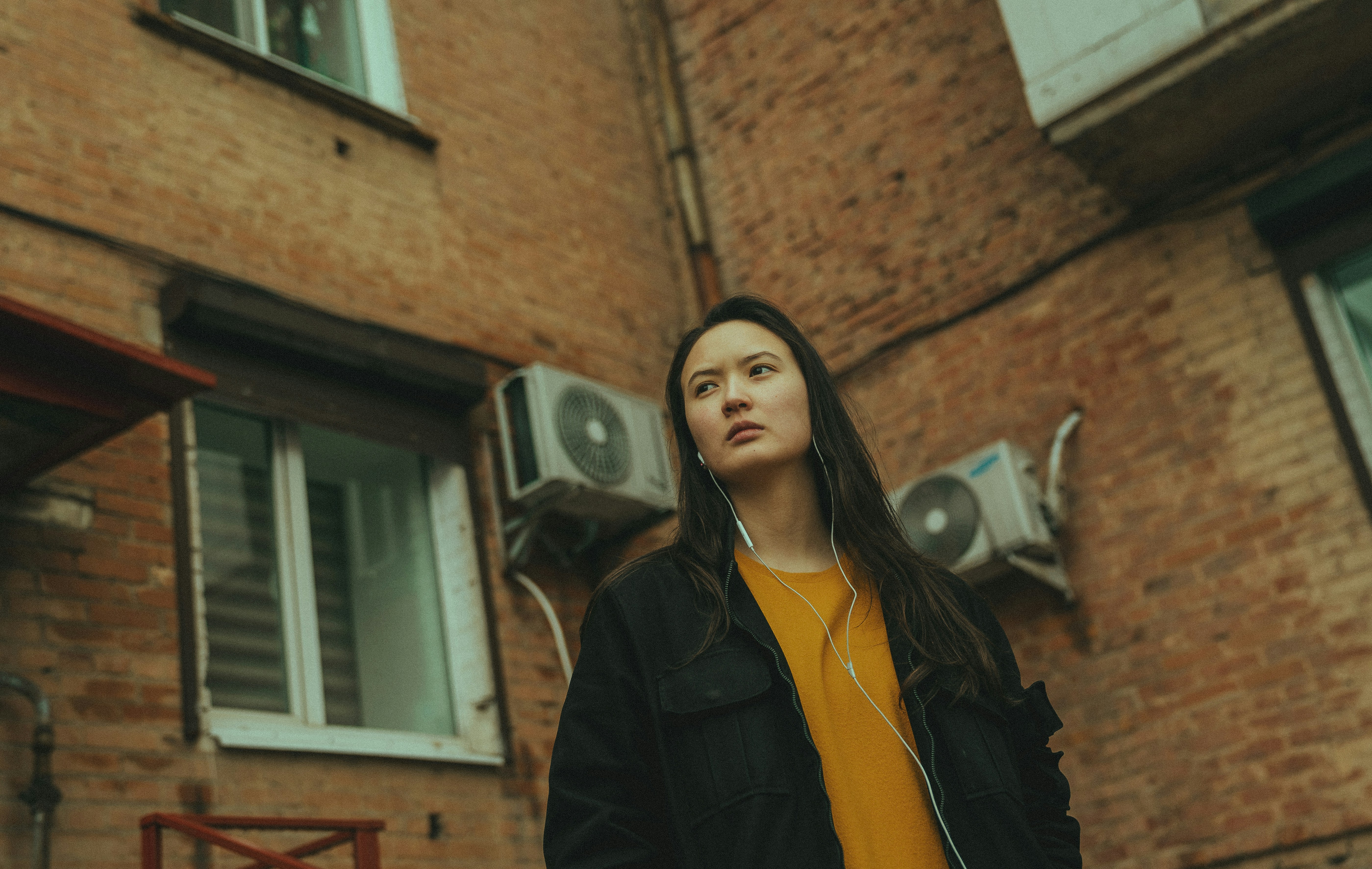 A woman standing in front of a brick building photo – Free Human Image ...