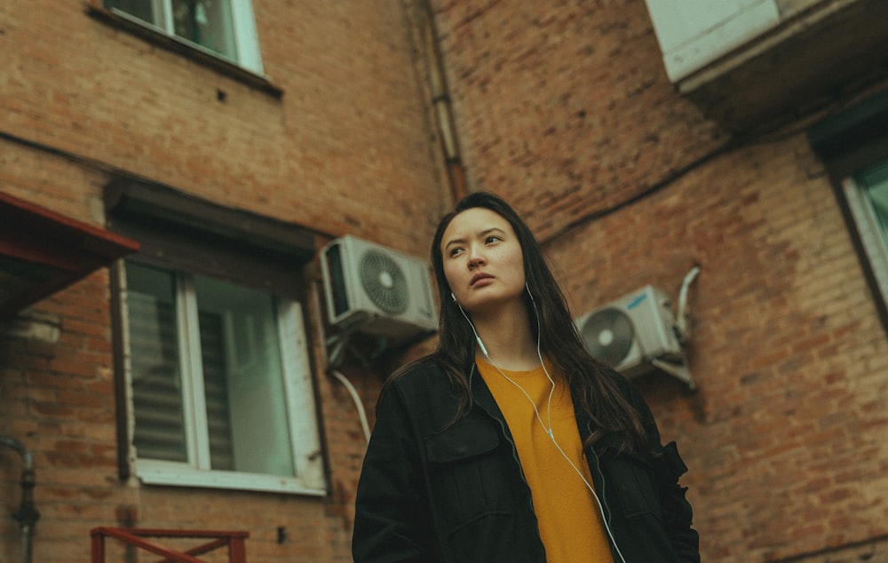 a woman standing in front of a brick building