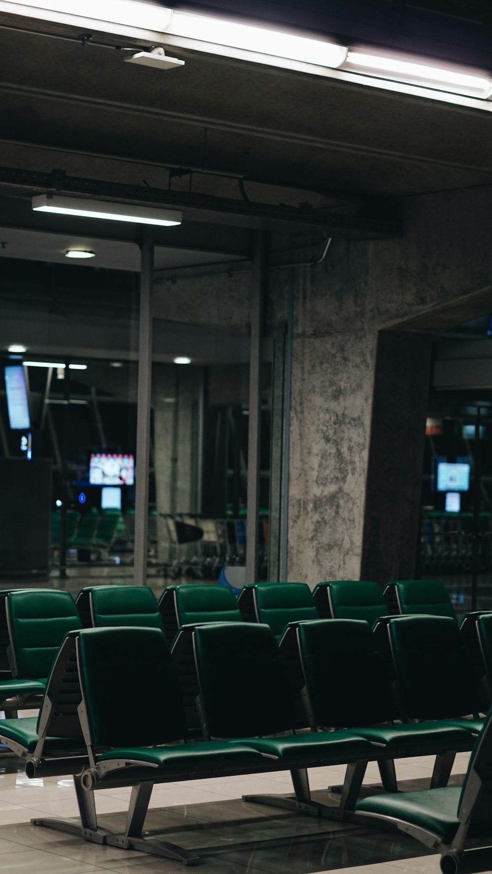 a row of green chairs sitting in front of a building