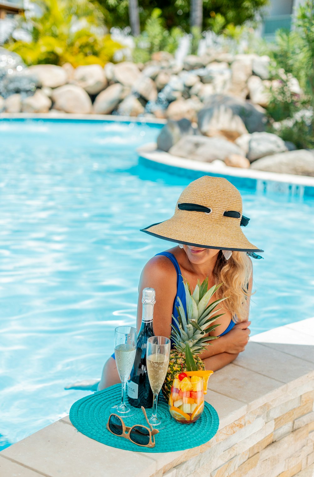 woman in brown sun hat holding pineapple