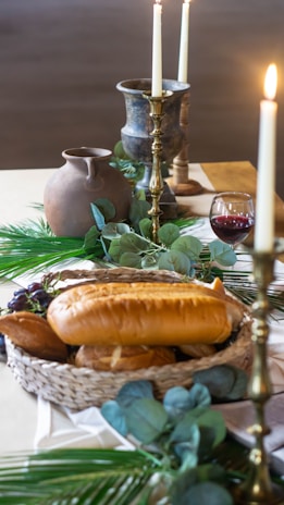 A warmly set dining table with glowing candles and a rustic bread basket reflecting a welcoming family meal.