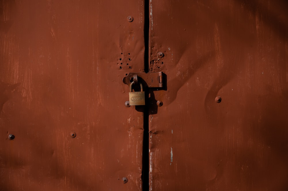 orange and silver padlock on orange door