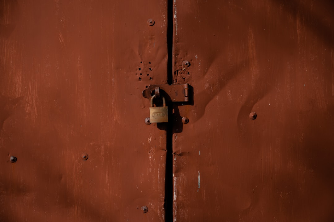orange and silver padlock on orange door,