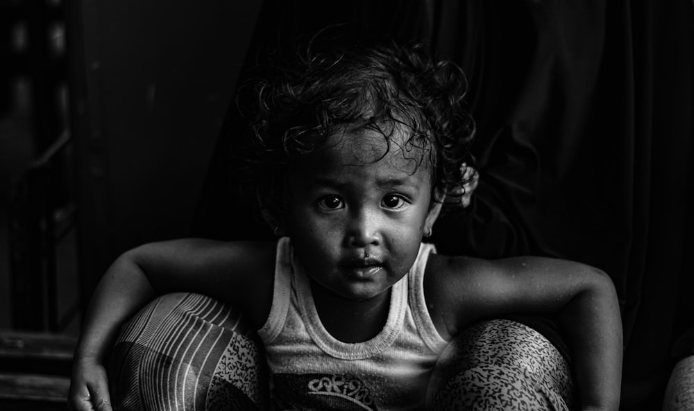 grayscale photo of child in tank top