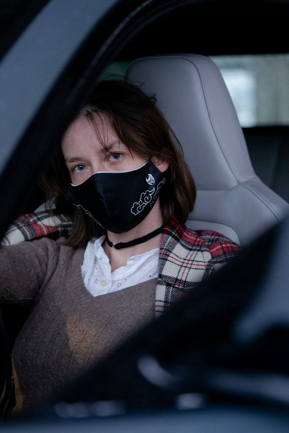 girl in white red and black plaid shirt wearing black mask