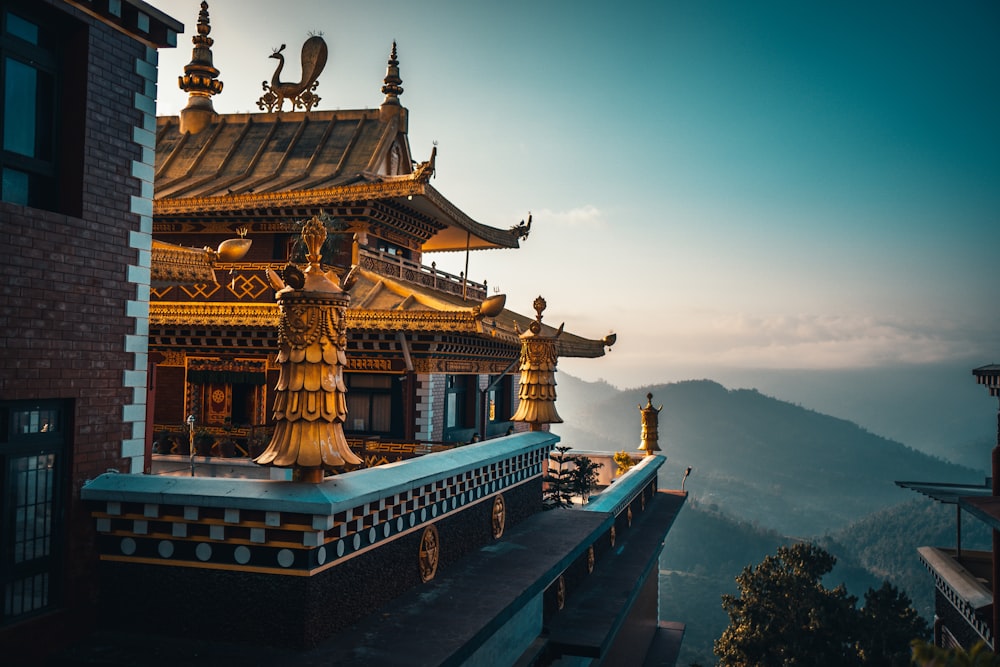 templo marrom e verde no topo da montanha durante o dia