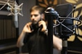 man in black singing in a sound studio