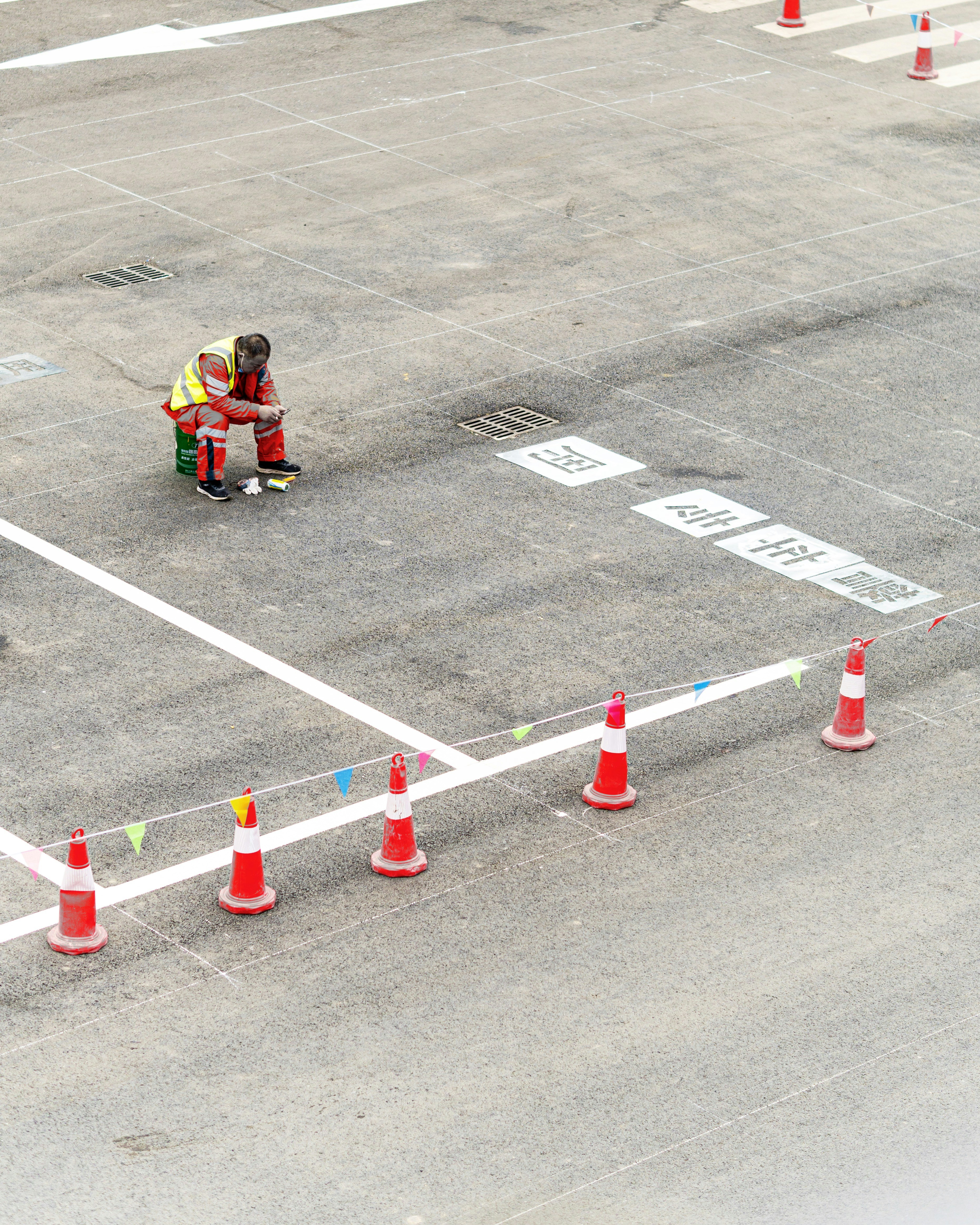 man in black jacket riding red and black ride on toy car on gray asphalt road