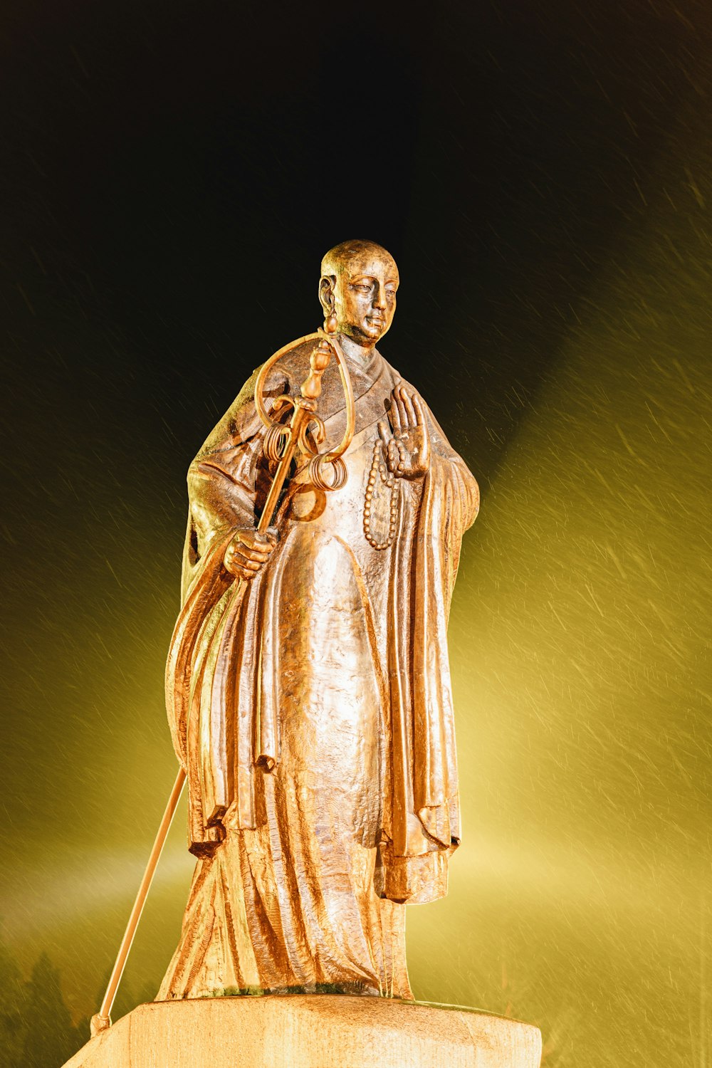 estátua de ouro do homem que segura a vara