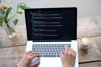 person using macbook pro on brown wooden table