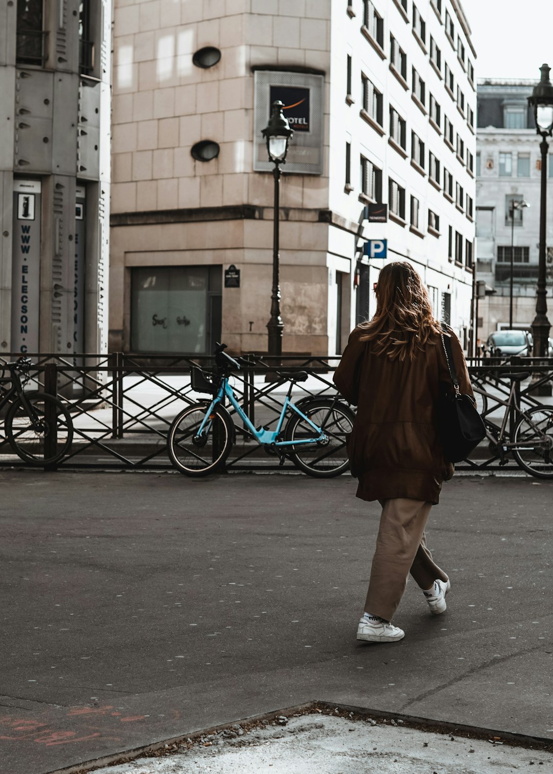 woman in black dress walking on sidewalk during daytime