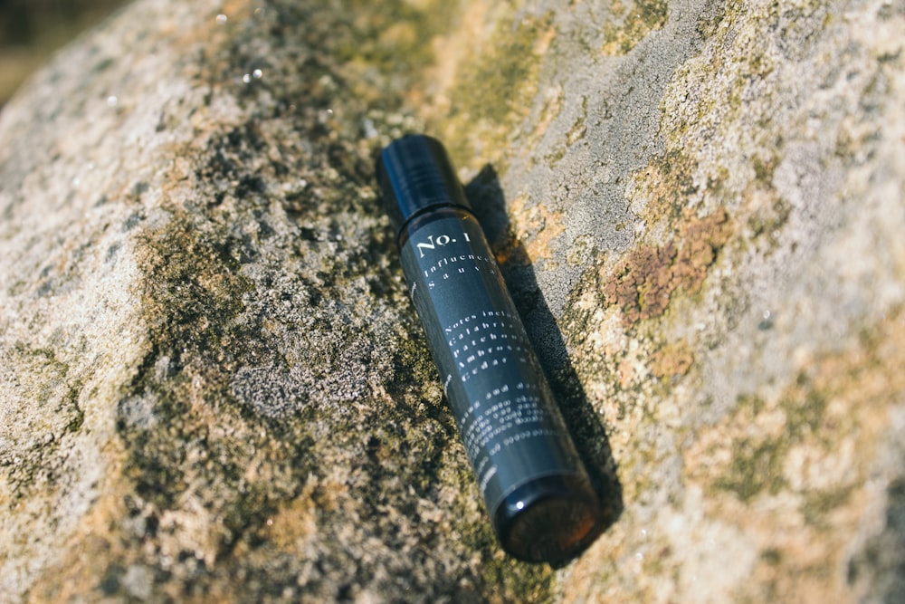 black tube bottle on brown and black marble table