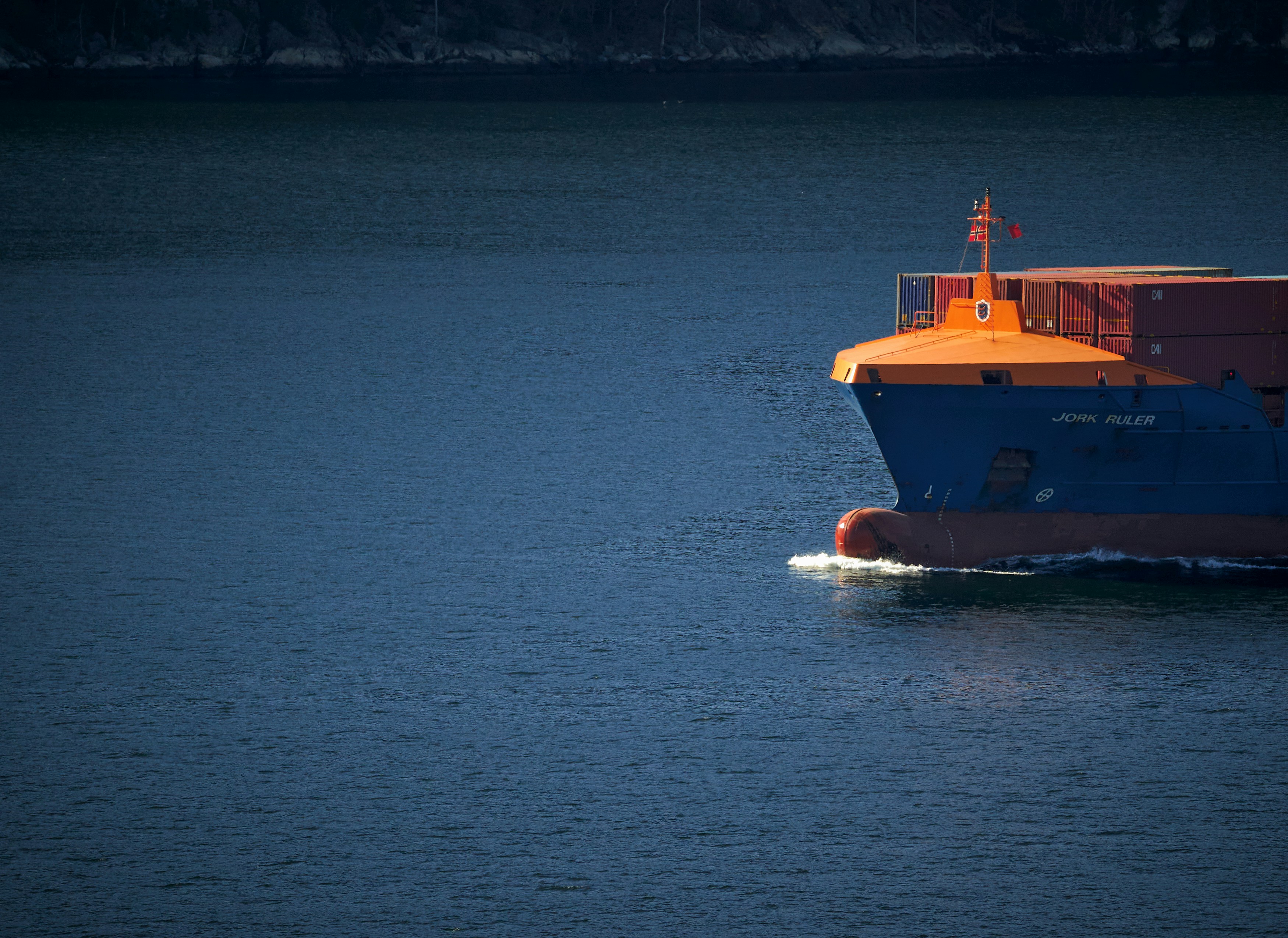 orange and white boat on blue sea during daytime