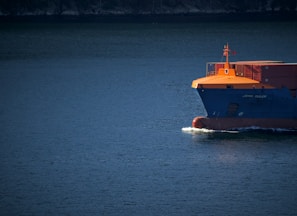 orange and white boat on blue sea during daytime