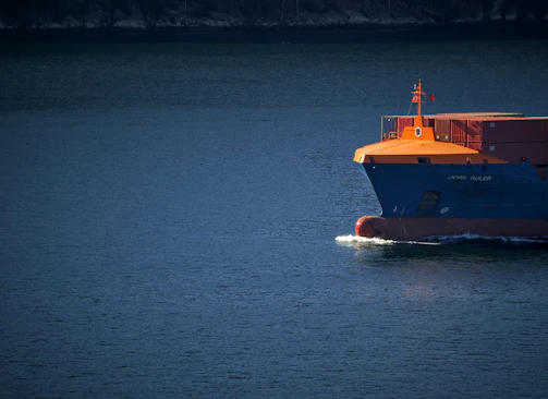 orange and white boat on blue sea during daytime