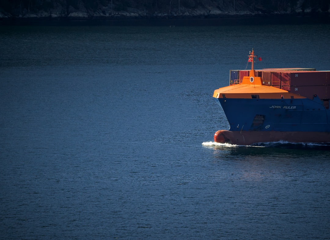 orange and white boat on blue sea during daytime