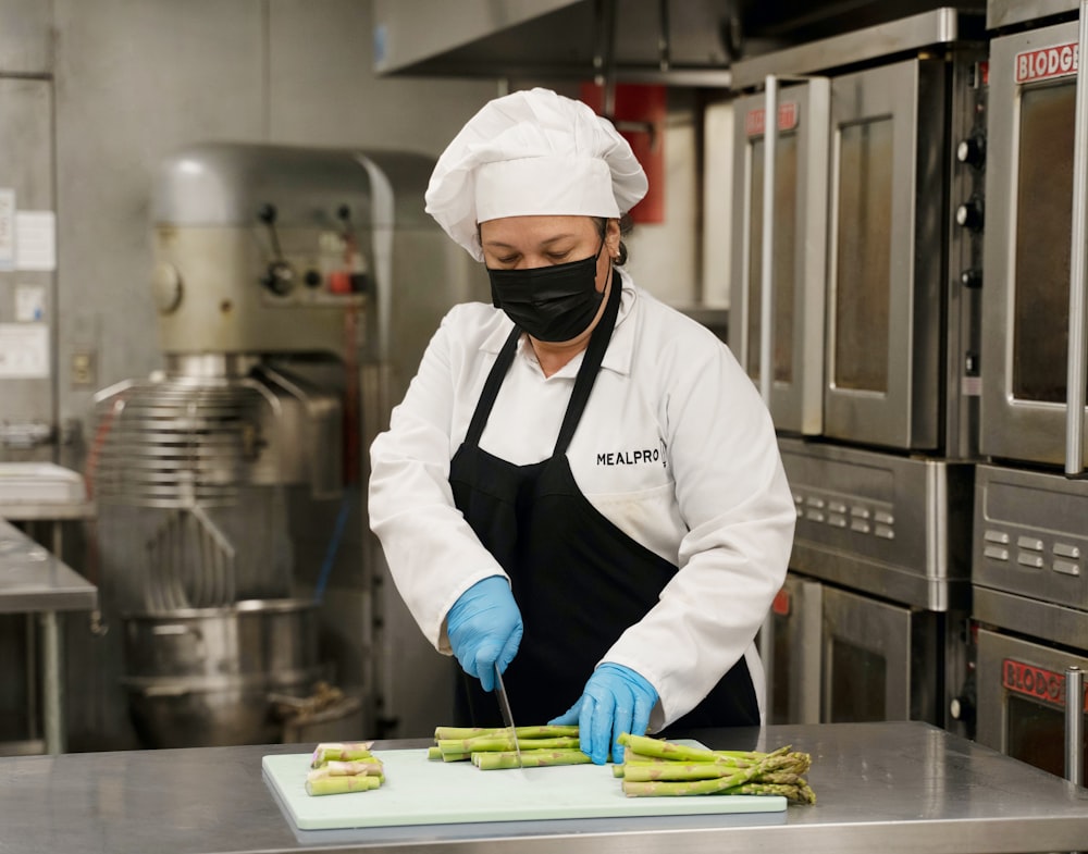 chef holding green and yellow plastic tray