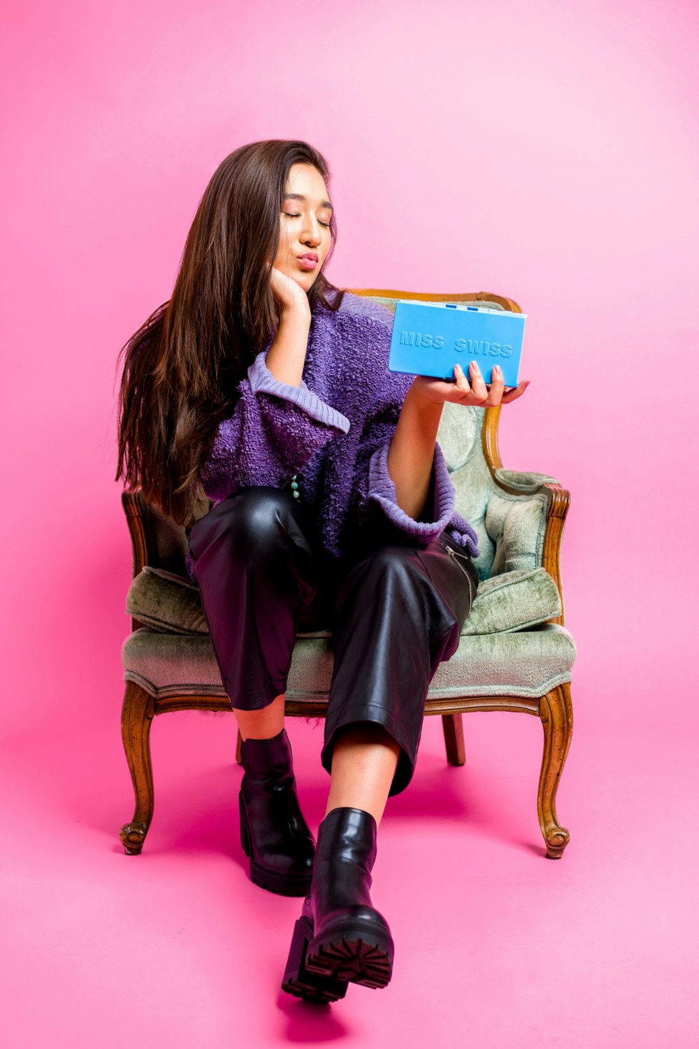 woman in purple long sleeve shirt sitting on brown wooden chair