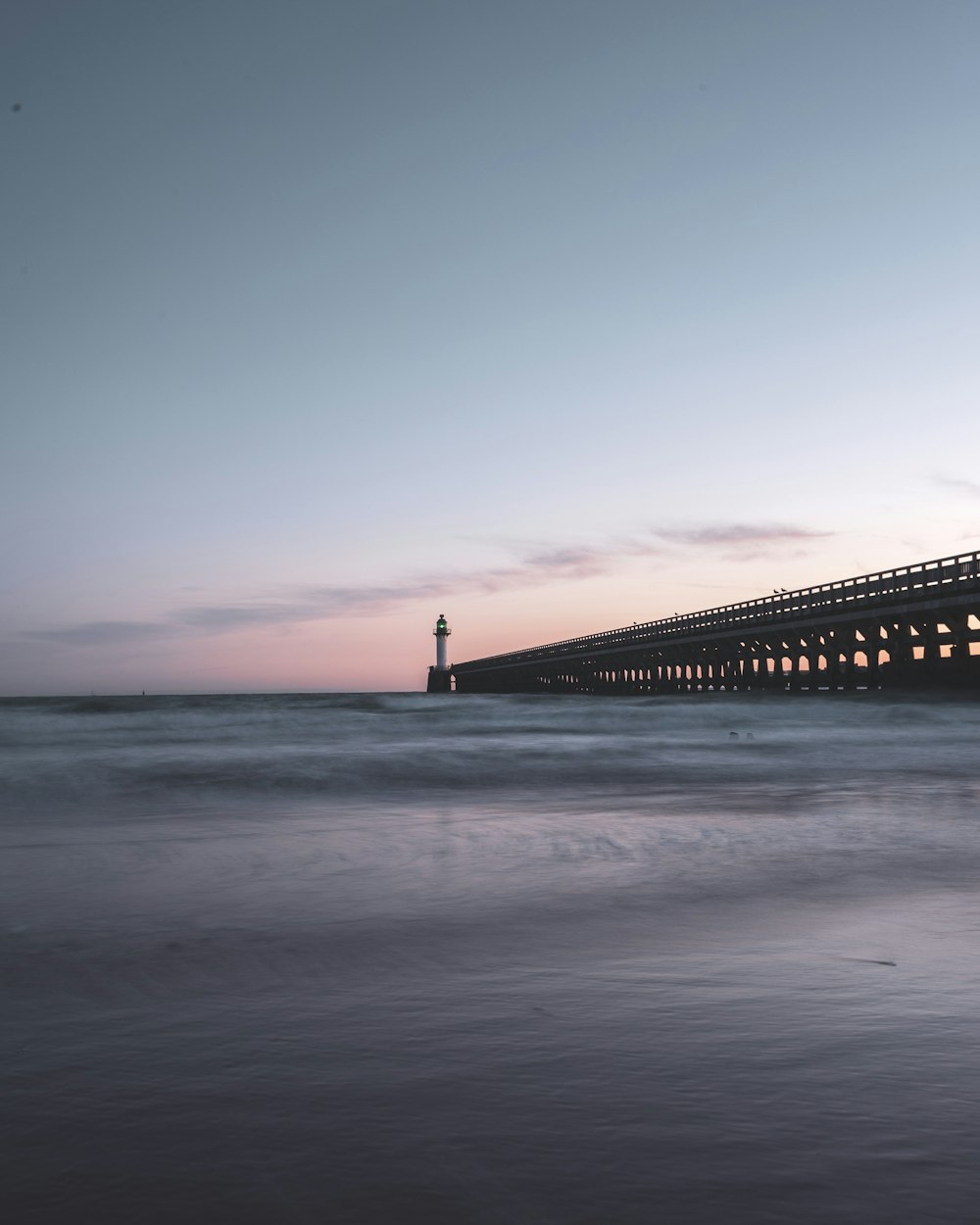 brown wooden dock on sea under blue sky during daytime